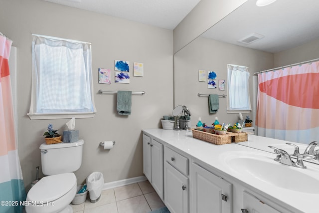 full bathroom with tile patterned flooring, toilet, vanity, and a wealth of natural light