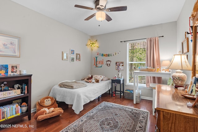 bedroom featuring baseboards, wood finished floors, and a ceiling fan