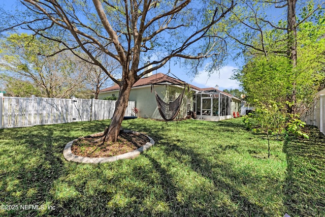 view of yard featuring glass enclosure and a fenced backyard