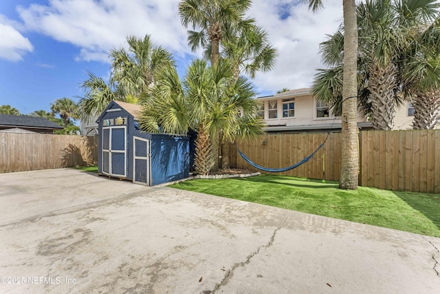 view of yard featuring a shed, fence, and an outbuilding