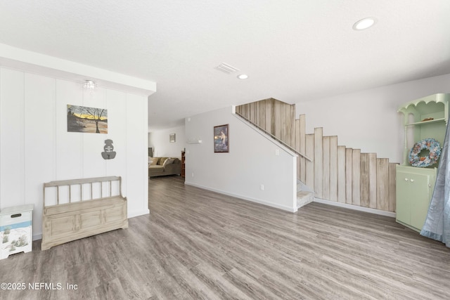 living room featuring stairs, visible vents, wood finished floors, and recessed lighting