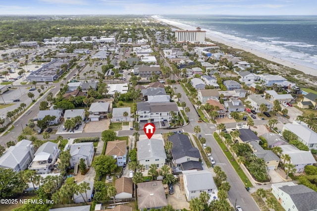 drone / aerial view with a water view, a residential view, and a beach view