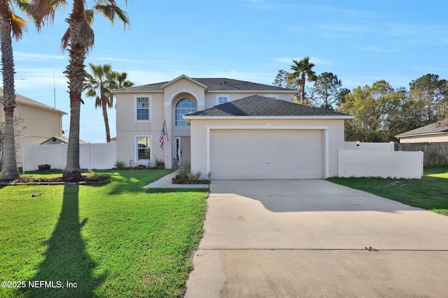 traditional-style house featuring a front lawn, fence, driveway, and stucco siding