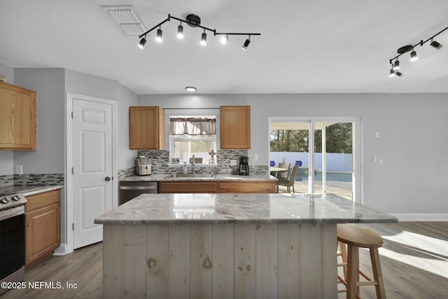 kitchen with light wood-type flooring, visible vents, a sink, tasteful backsplash, and stainless steel appliances