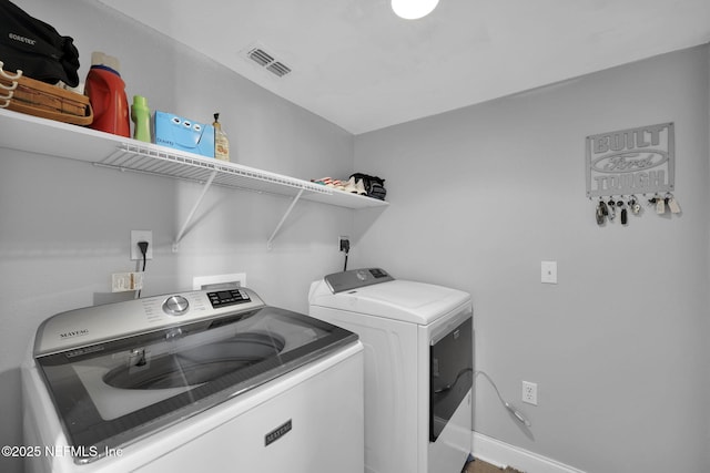 washroom with washer and clothes dryer, laundry area, baseboards, and visible vents