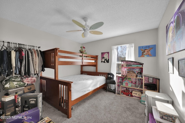 bedroom with ceiling fan, carpet, and a textured ceiling