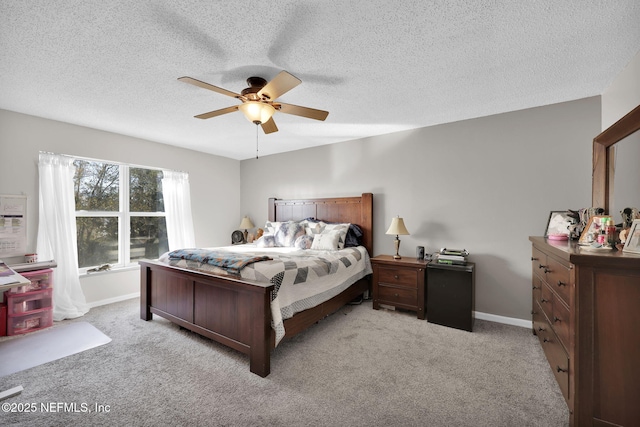 bedroom featuring light colored carpet, baseboards, and ceiling fan