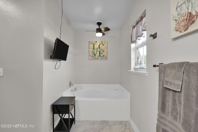 bathroom featuring a bath, marble finish floor, baseboards, and a ceiling fan