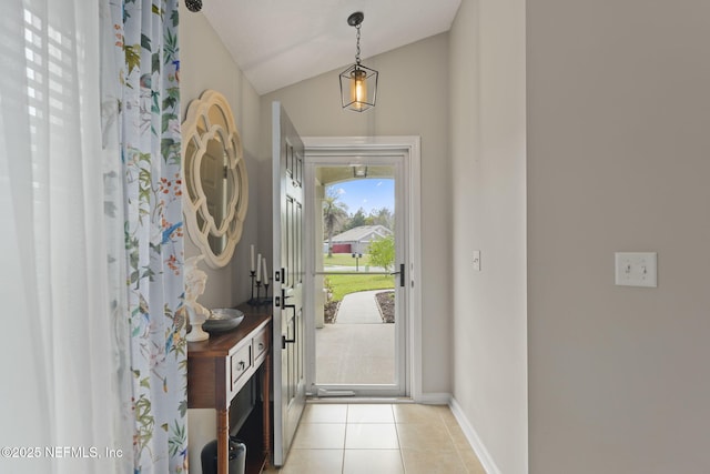 entrance foyer with lofted ceiling, light tile patterned floors, and baseboards