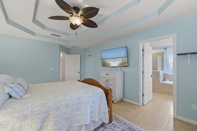 bedroom featuring visible vents, connected bathroom, baseboards, light tile patterned flooring, and a raised ceiling