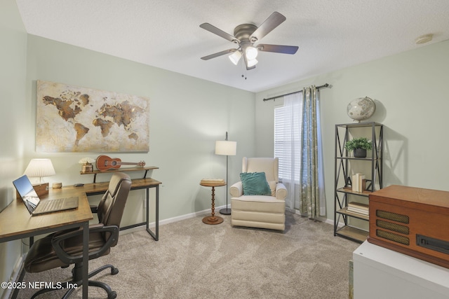 carpeted office space with a ceiling fan, baseboards, and a textured ceiling