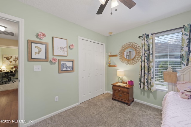 carpeted bedroom with visible vents, baseboards, a closet, and ceiling fan