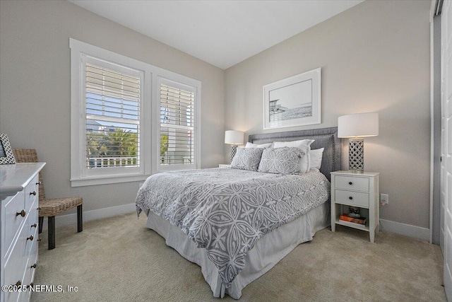 bedroom featuring light carpet and baseboards