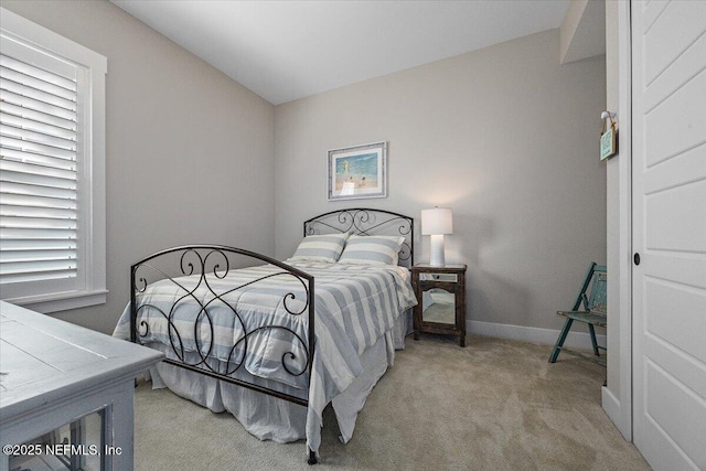 bedroom with baseboards and light carpet