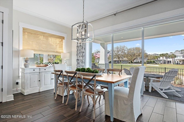 dining space with an inviting chandelier, a healthy amount of sunlight, and dark wood-style flooring