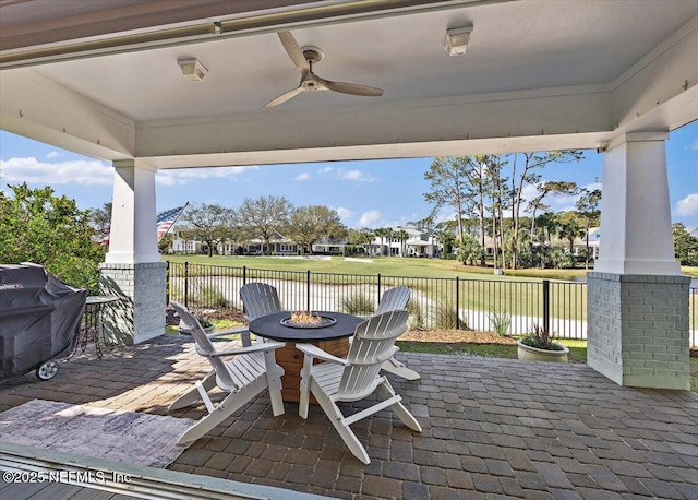 view of patio with area for grilling, a ceiling fan, fence, and an outdoor fire pit