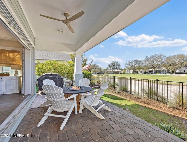 view of patio featuring a fenced backyard, a fire pit, area for grilling, and ceiling fan