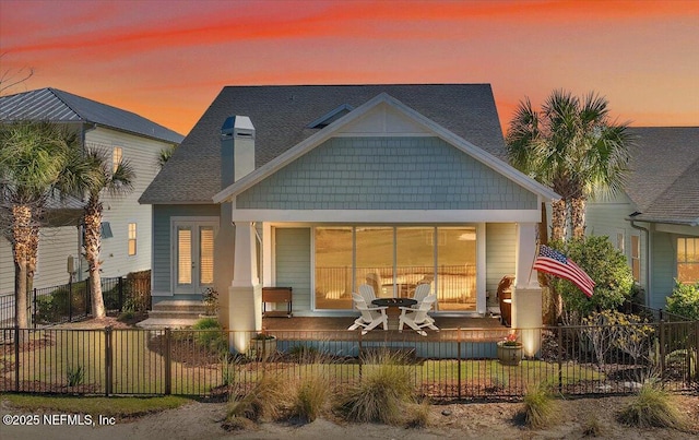 back of property with a porch and a fenced front yard