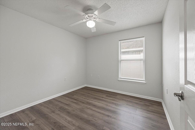 unfurnished room featuring a ceiling fan, baseboards, dark wood-style flooring, and a textured ceiling