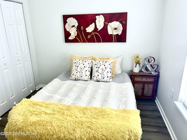 bedroom featuring a closet, baseboards, and wood finished floors