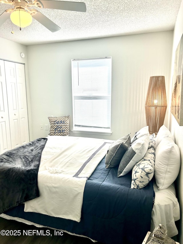 bedroom featuring a closet, a textured ceiling, and ceiling fan