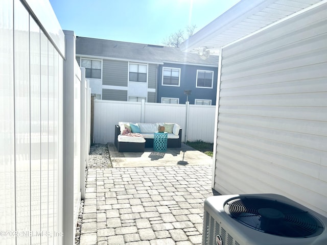 view of patio / terrace with central AC unit, a fenced backyard, and outdoor lounge area