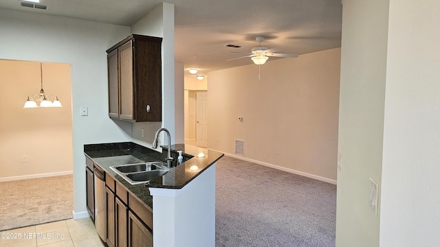 kitchen featuring visible vents, dark brown cabinetry, light colored carpet, ceiling fan with notable chandelier, and a sink