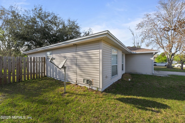 view of home's exterior featuring a yard and fence