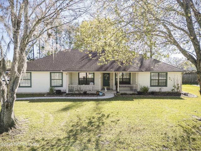 ranch-style home featuring a porch, a front yard, and a shingled roof