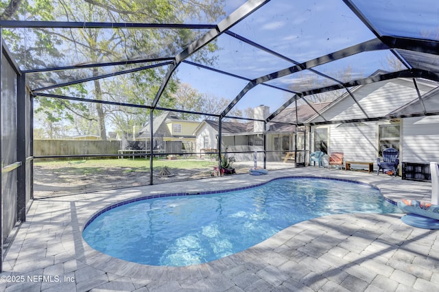 view of pool featuring glass enclosure, a patio area, a fenced backyard, and a fenced in pool