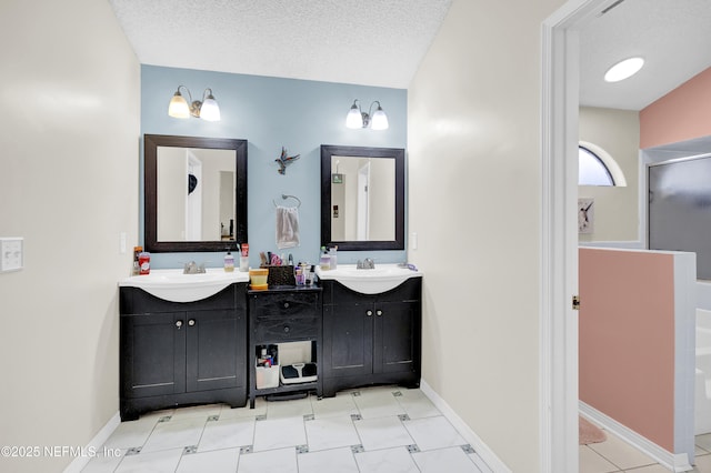 full bath featuring a sink, double vanity, baseboards, and a textured ceiling