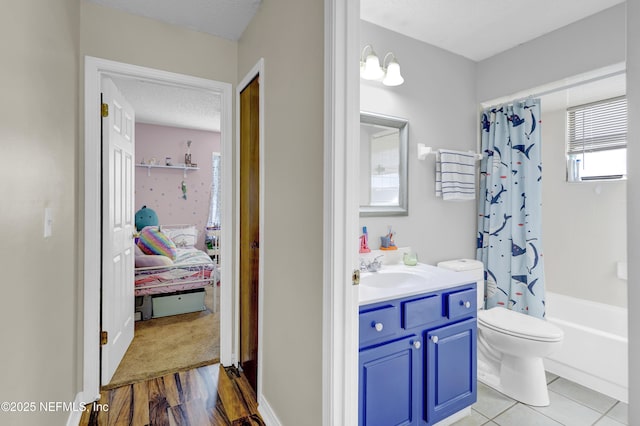 bathroom with a textured ceiling, toilet, shower / tub combo, vanity, and ensuite bath