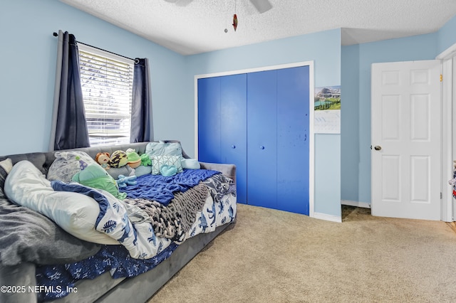 bedroom with carpet, a closet, ceiling fan, and a textured ceiling