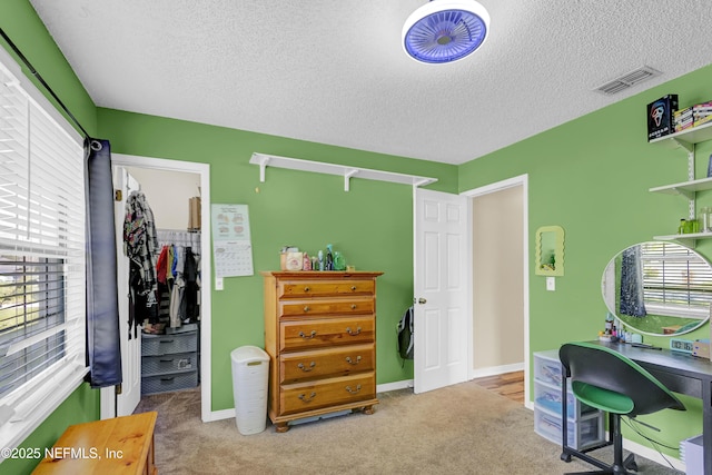 home office with a healthy amount of sunlight, visible vents, and carpet flooring