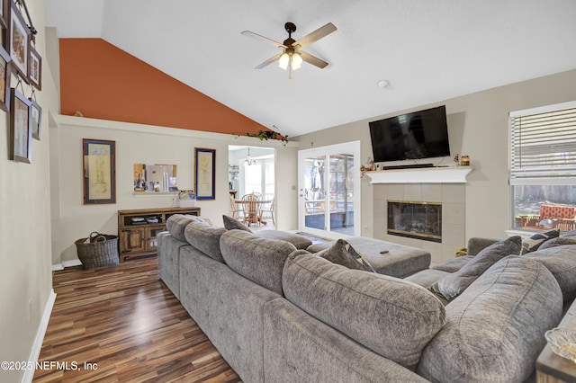 living room with lofted ceiling, dark wood-type flooring, a fireplace, a ceiling fan, and baseboards