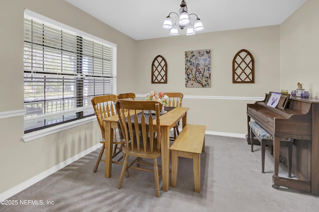 carpeted dining room featuring baseboards and a chandelier