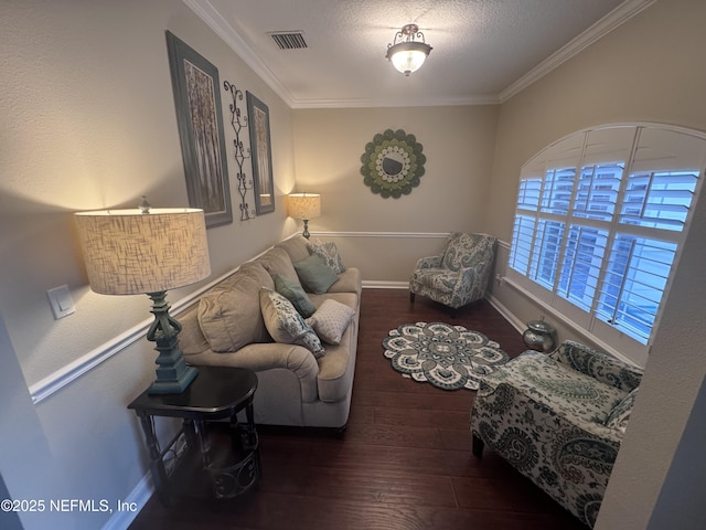 living room with visible vents, baseboards, ornamental molding, wood finished floors, and a textured ceiling