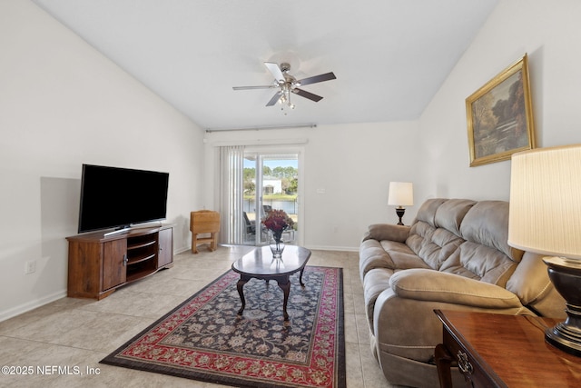 living area featuring lofted ceiling, light tile patterned floors, a ceiling fan, and baseboards