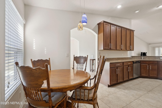 dining space featuring lofted ceiling, recessed lighting, arched walkways, and light tile patterned flooring