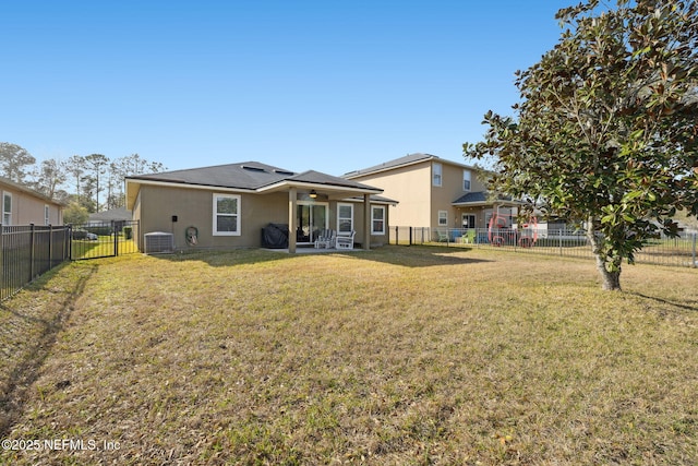 back of house with ceiling fan, central AC, a yard, and a fenced backyard