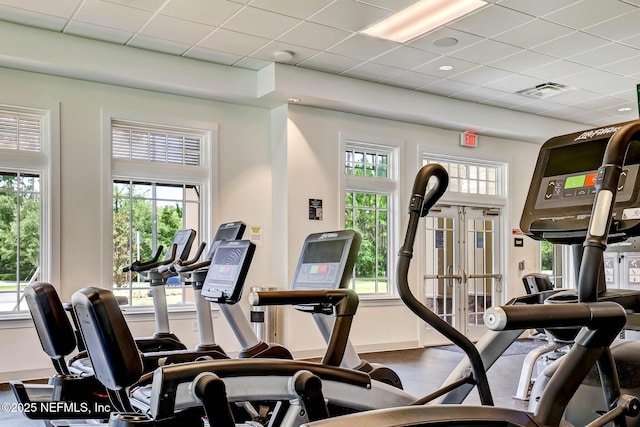 exercise room featuring baseboards, visible vents, a drop ceiling, and french doors