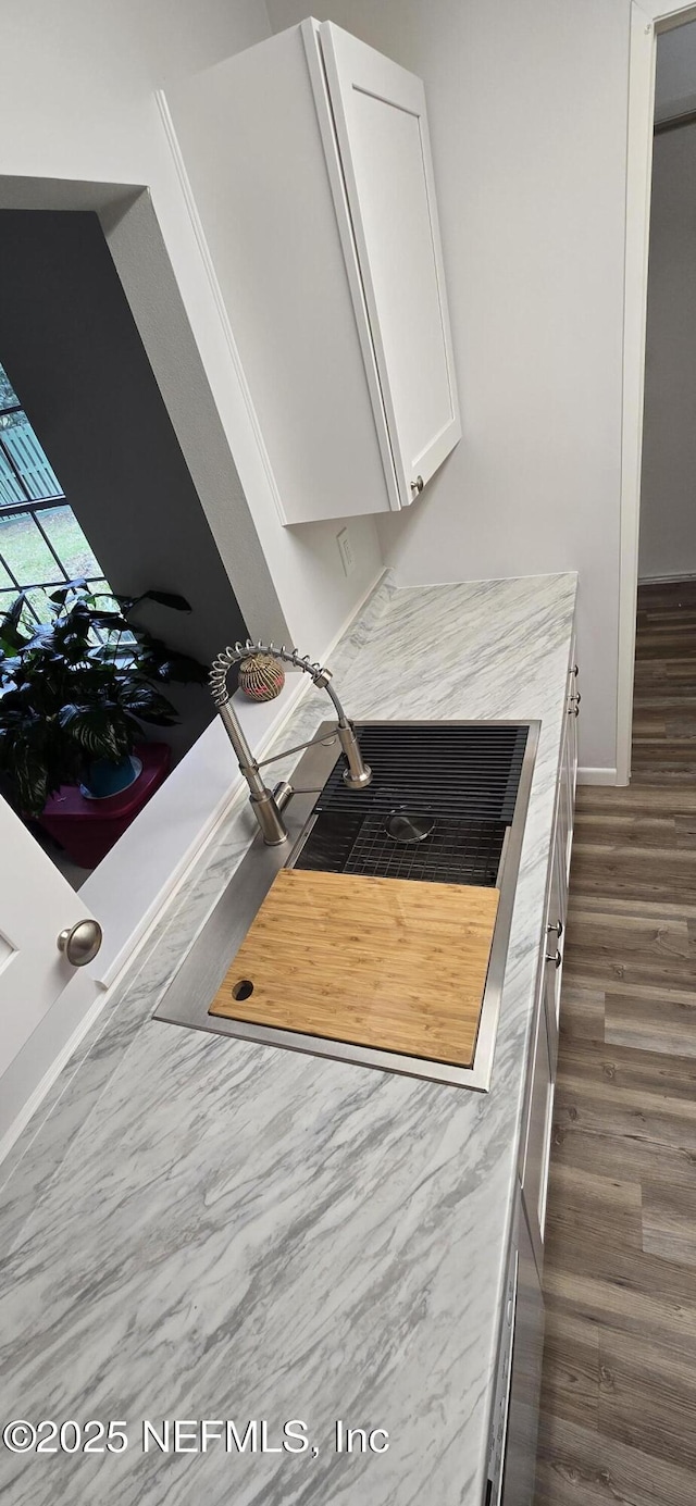 room details with light countertops, dark wood-style flooring, and white cabinetry