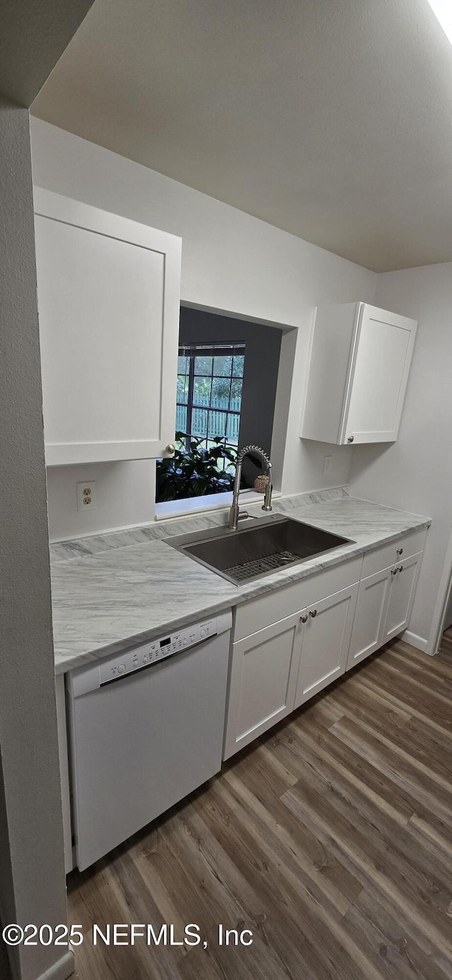 kitchen featuring dark wood-style floors, light countertops, white cabinetry, white dishwasher, and a sink