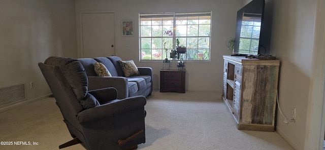 living room with carpet floors, visible vents, and baseboards