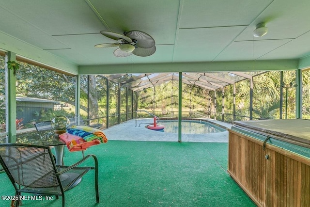 pool with glass enclosure, a hot tub, a patio area, and ceiling fan