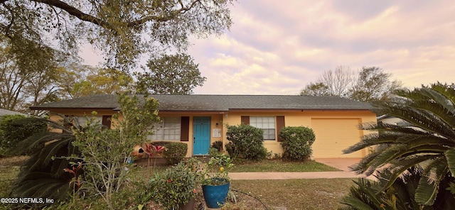 ranch-style house with a garage and stucco siding