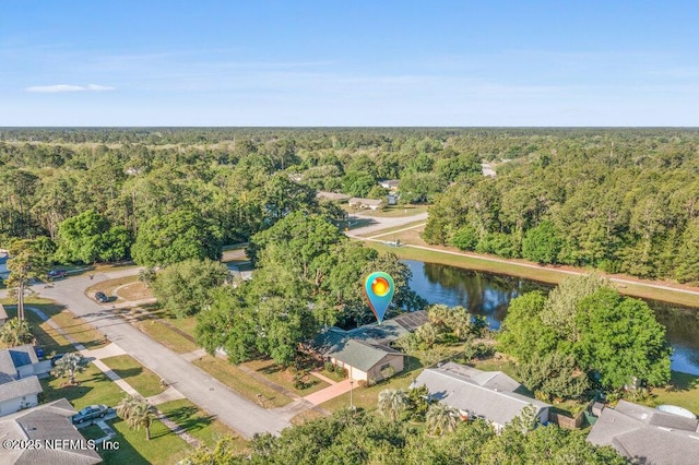 birds eye view of property with a water view and a wooded view