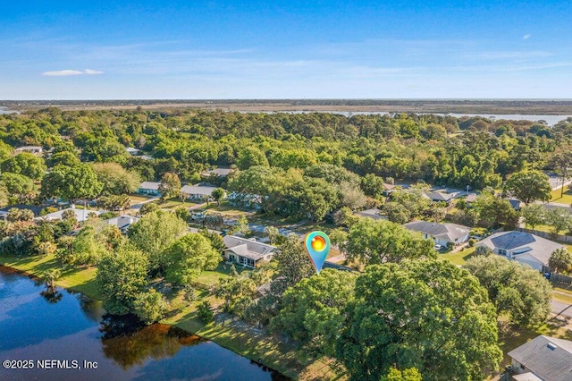 birds eye view of property featuring a water view and a wooded view