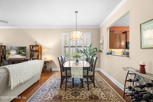 dining space featuring crown molding, dark wood-style floors, and baseboards