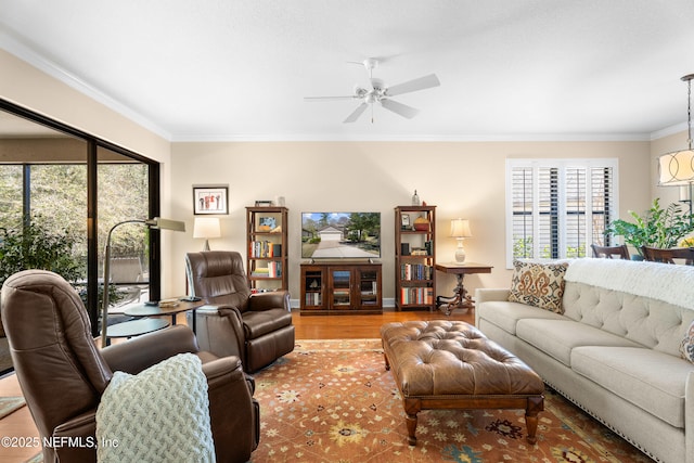 living room with ceiling fan, wood finished floors, baseboards, and ornamental molding